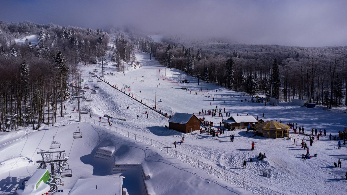 Skijaška staza sa žičarom u šumi prekrivenoj snijegom